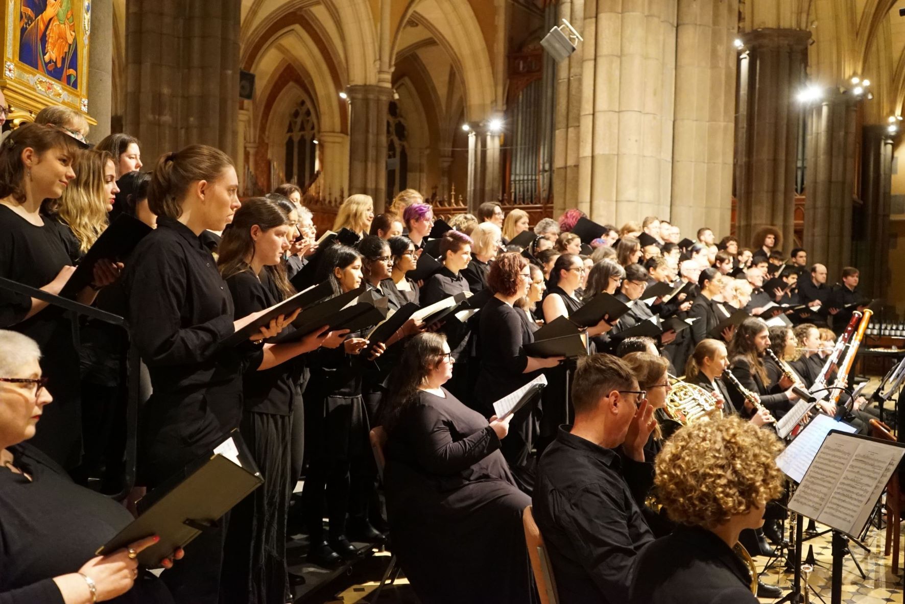 An image of choristers reading from their sheet music while performing in one of our previous concerts! This could be you!